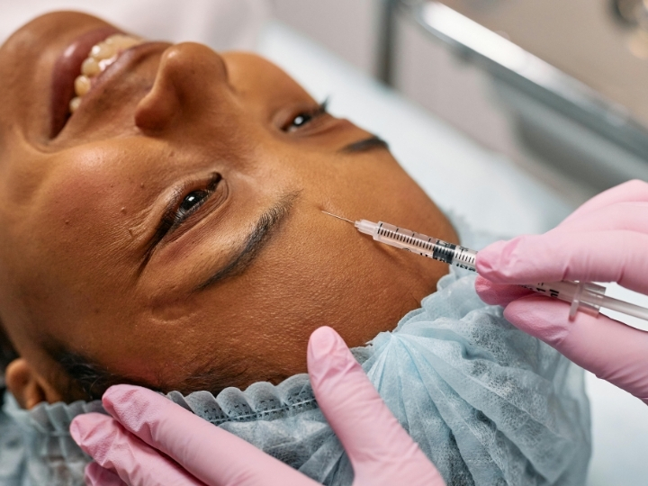 Profissional aplicando botox facial em paciente na Ollige Clinic, localizada na Avenida Paulista