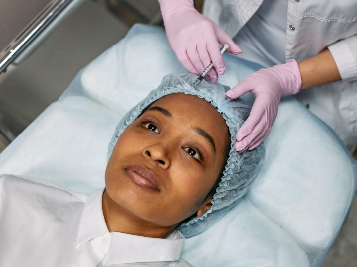 Profissional aplicando botox no rosto de uma paciente na Ollige Clinic